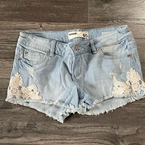 Mid-waist Garage denim shorts with cream crochet detailing on the sides Size 05